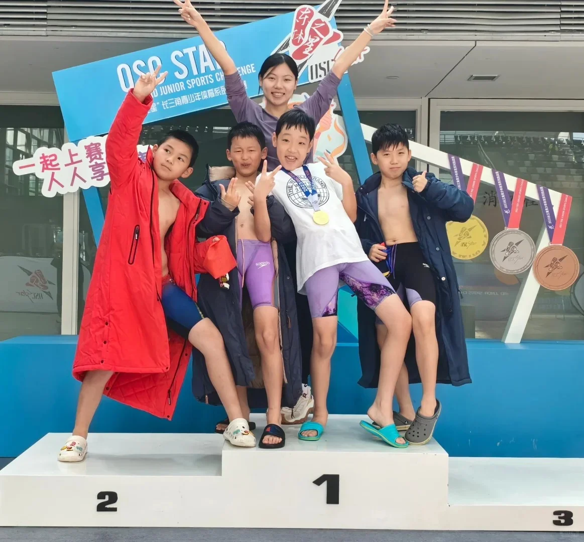 Young swimmers celebrating on a competition podium